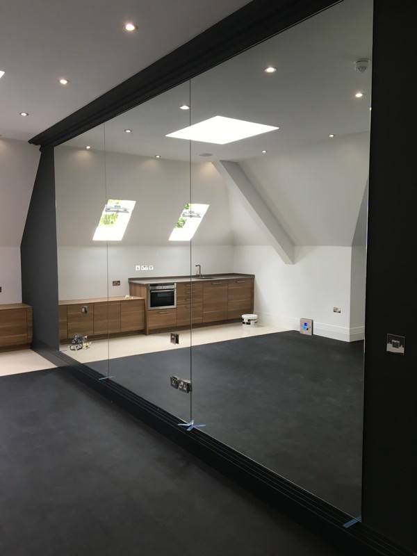 Frameless glass partition in loft conversion by Chingford glaziers