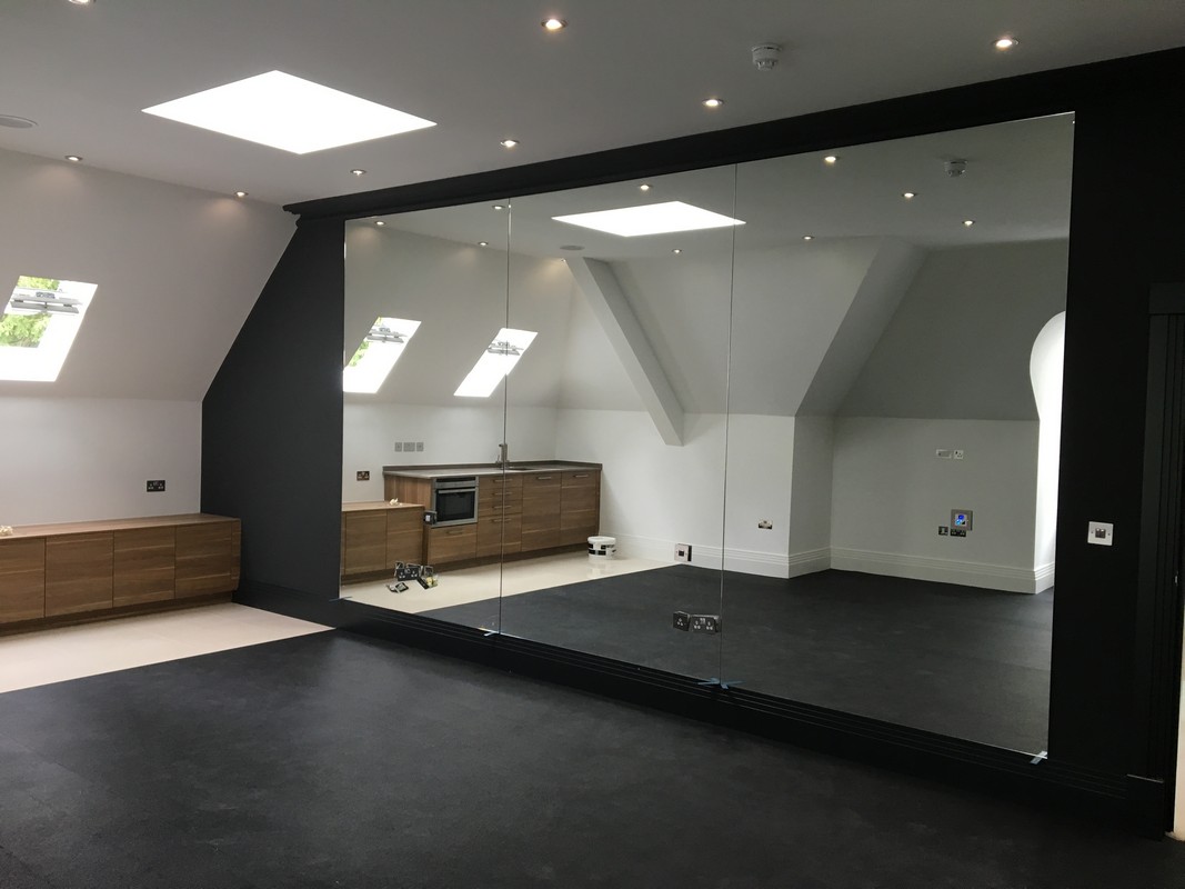 Frameless glass wall dividing loft conversion in Chingford