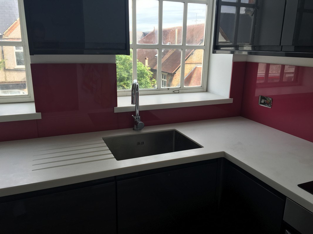 Deep plum coloured glass splashback in modern Chingford kitchen